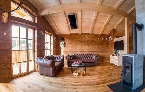 ein Wohnzimmer mit 2 Ledersofas und einem TV in der Unterkunft Jagdhütte in Lachtal