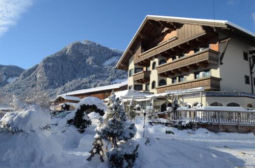 a ski lodge with a christmas tree in the snow at derNeuwirt in Schwendau