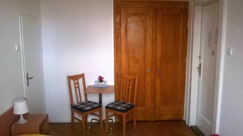 a room with a table and two chairs and a door at Penzion Villa Gerlach in Nový Smokovec
