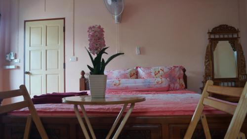 a room with a table and a couch with a vase of flowers at Kata Apartment in Kata Beach