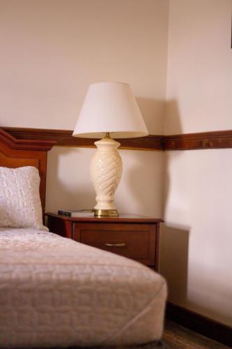 a lamp sitting on a table next to a bed at Malabi Exclusive Lodges in Lilongwe