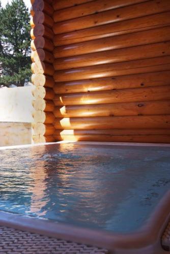 - une piscine avec un mur en bois et de l'eau dans l'établissement Chalet Ana & SPA, aux Angles