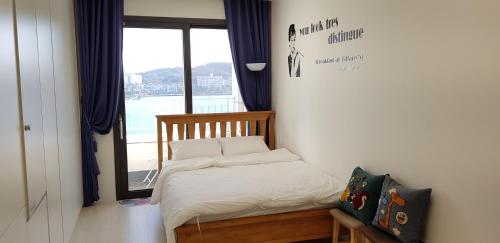 a small bed in a room with a window at Nadree House 1 in Sokcho