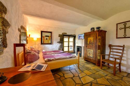 a bedroom with a bed and a table and a chair at Hofatelier Menacher in Neureichenau