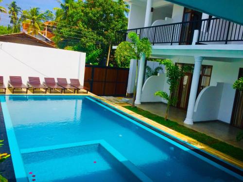 a swimming pool in front of a house at Kalu mirissa in Mirissa