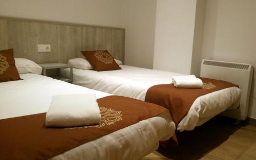 a hotel room with two beds with brown and white blankets at Apartamentos Sabica Nevada Plaza in Sierra Nevada