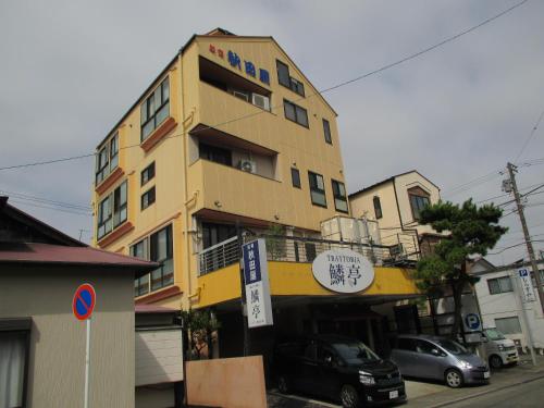 a yellow building with cars parked in front of it at Akitaya Annex in Kamakura