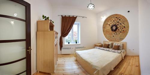 Babylon Apartments On Dubenska Street في روفنو: غرفة نوم بسرير كبير ونافذة