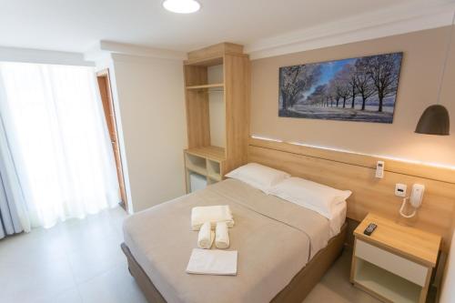a hotel room with a bed and a telephone at Pousada Nascer do Sol in Arraial do Cabo