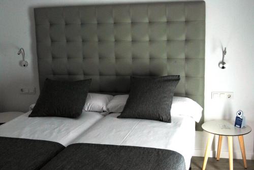a large bed with a large headboard in a bedroom at Estudiotel Alicante in Alicante