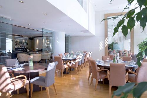 a restaurant with tables and chairs and a bar at Golden Age Athens Hotel in Athens