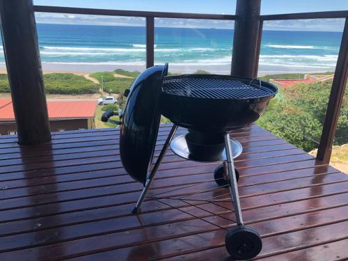 a grill on a porch with the ocean in the background at Pienaars Guesthouse in Groot Brak Rivier