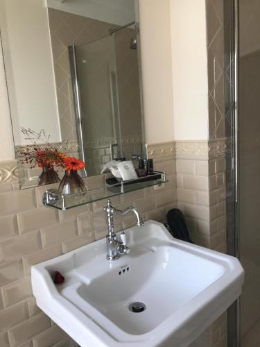 a bathroom with a white sink and a mirror at Keizershouse Amsterdam in Amsterdam