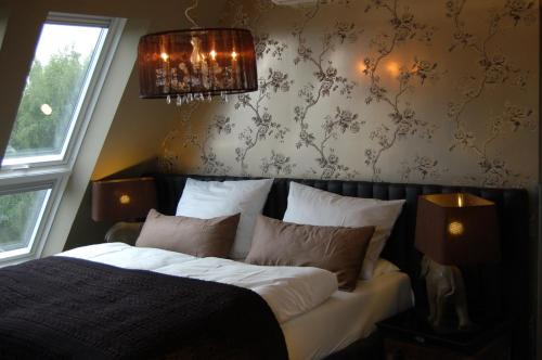a bedroom with a bed and a chandelier at Boutique-Hotel GEORGES in Essen