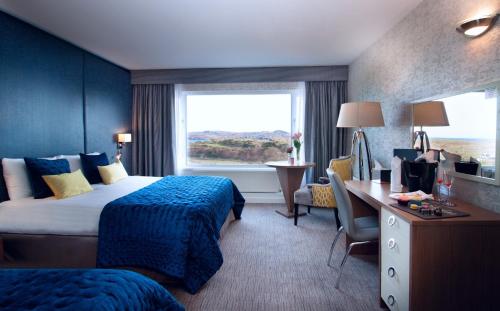 a hotel room with two beds and a desk and a window at Shandon Hotel & Spa in Dunfanaghy