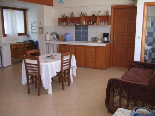een keuken en eetkamer met een tafel en stoelen bij Studios Elpida in Tiros