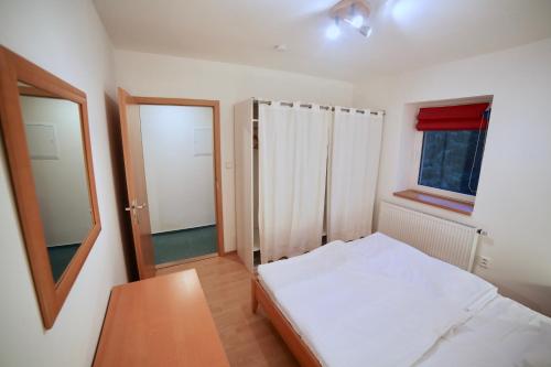 a small bedroom with a bed and a window at Wellness Apartmán Pec in Pec pod Sněžkou