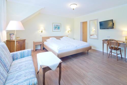 a hotel room with a bed and a couch at Romantik Waldhotel Mangold in Bergisch Gladbach