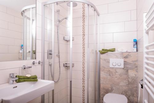a bathroom with a shower with a sink and a toilet at Piz Arina Inklusiv Premium - Card in Galtür