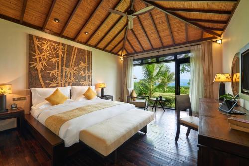 a bedroom with a large bed and a large window at Amiana Resort Nha Trang in Nha Trang