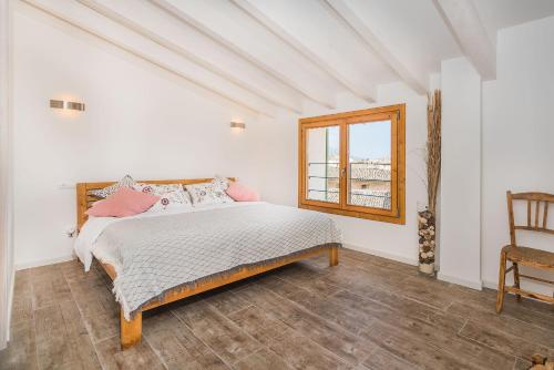 1 dormitorio con cama, ventana y silla en Can Bons Aires by SunVillas Mallorca, en Pollensa