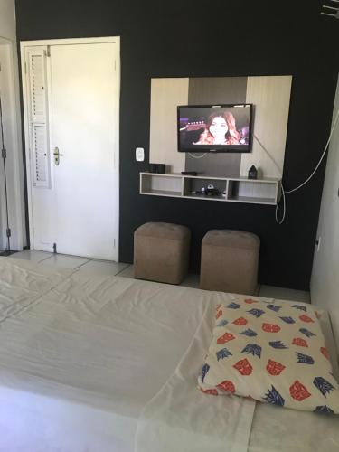 a bedroom with a bed and a flat screen tv at Toca do guaxinim in Itarema