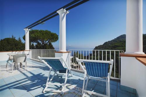 a balcony with chairs and a view of the ocean at Suite Villa Carolina in Capri
