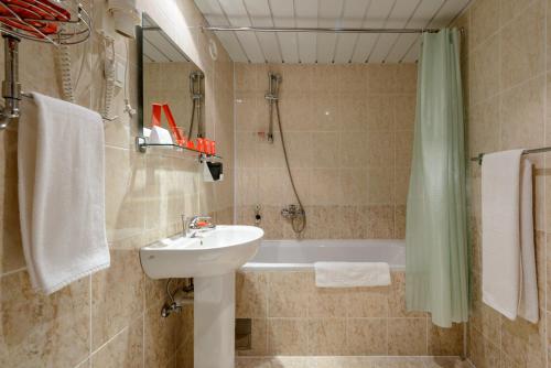 a bathroom with a sink and a bath tub at AZIMUT Hotel Mirny in Mirnyy