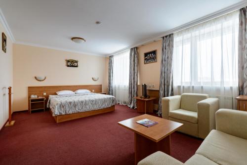 Habitación de hotel con cama y sofá en AZIMUT Hotel Mirny en Mirnyy