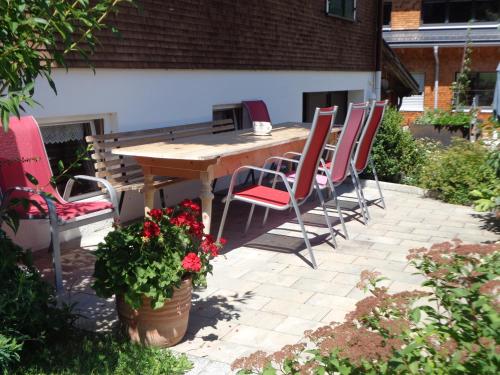 a wooden table and chairs on a patio at Haus Annelies in Au im Bregenzerwald