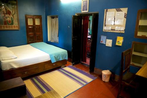 1 dormitorio con cama y pared azul en Ram Bhawan Residency, en Varanasi