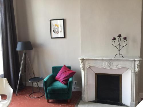 a living room with a green chair and a fireplace at Maison Dormoy in Marseille