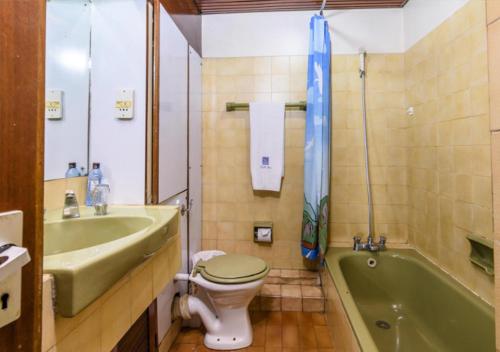 a bathroom with a toilet and a sink and a tub at Chester Hotel and Suites in Nairobi