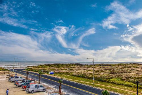 a row of cars parked in a parking lot next to the beach at Pathway 14820 in Padre Island