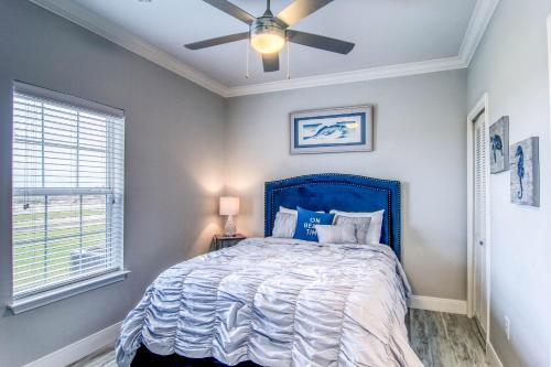 a bedroom with a blue bed with a ceiling fan at Pathway 14820 in Padre Island