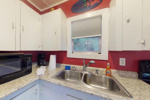 eine Küche mit einer Spüle aus Edelstahl und einem Fenster in der Unterkunft Acapulco's Hideaway in Lake Murray Shores