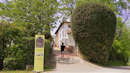 a man walking down a sidewalk next to a large bush at Borgo La Casaccia in Montaione
