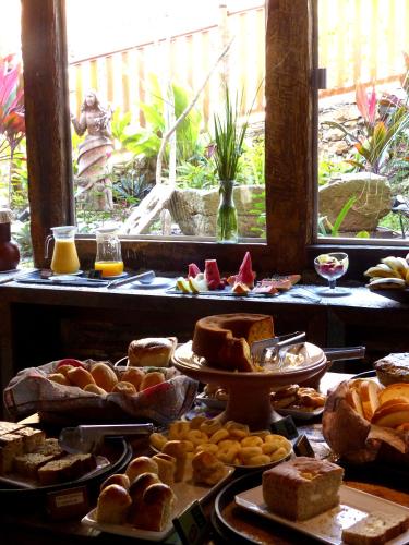 a table with various types of bread and pastries at Pouso da Chica in Diamantina