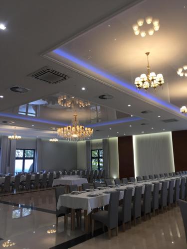 a banquet hall with white tables and chairs and chandeliers at Hotel Copernicus in Lubawa