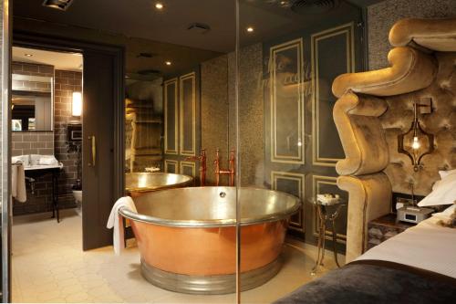uma grande casa de banho com banheira e um quarto em The Impeccable Pig em Sedgefield