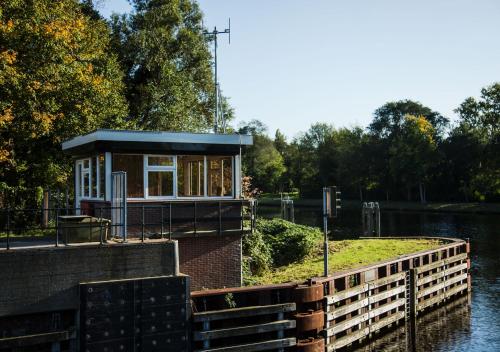 een klein gebouw aan de kant van een waterlichaam bij SWEETS - Buiksloterdraaibrug in Amsterdam