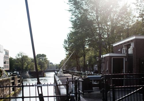 a view of a canal with a fence and a river at SWEETS - Scharrebiersluis in Amsterdam