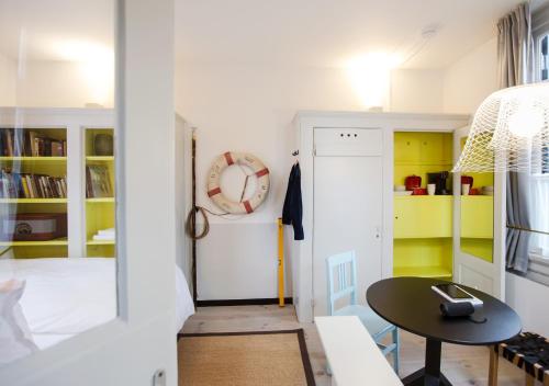 um pequeno quarto com uma mesa e armários amarelos em SWEETS - Scharrebiersluis em Amsterdã