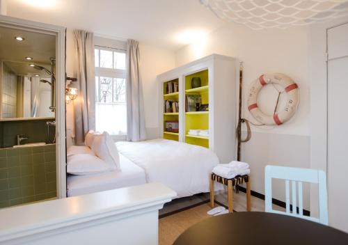 a living room with a white couch and a bathroom at SWEETS - Scharrebiersluis in Amsterdam