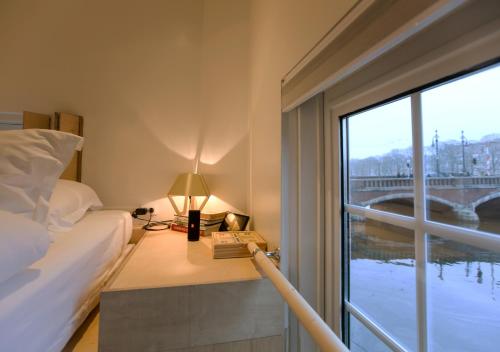 a bedroom with a bed and a window with a view of a bridge at SWEETS - Nieuwe Amstelbrug in Amsterdam