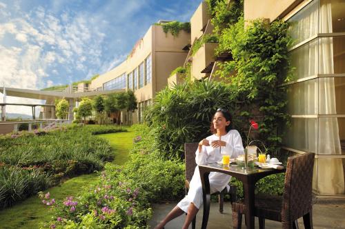 a woman sitting at a table in front of a building at PULSE GRANDE Hotel Putrajaya in Putrajaya