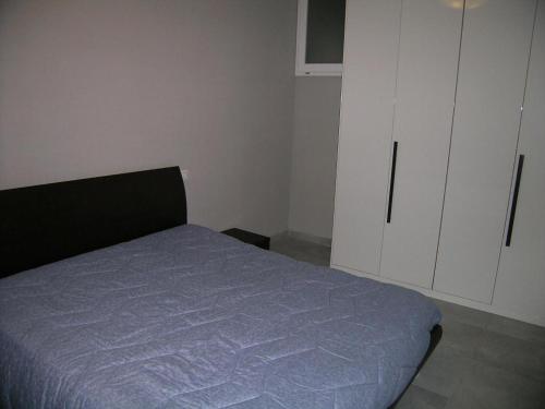 1 dormitorio con 1 cama y armario blanco en Appartamento Ateleta via Colle Sisto, en Ateleta