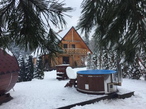 a snow covered yard with a house in the background at Wypoczynek na Mazurach U Sebka in Łukta