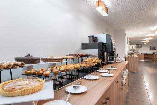 a bakery with a long counter with pastries on it at Eurostars Oasis Plaza in Figueira da Foz