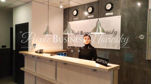 a woman standing behind a counter in a office at PEOPLE Business Novinsky Hotel in Moscow